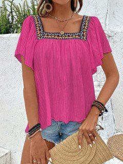 Angled front view of the fuchsia embroidered square-neck blouse, showing its silhouette and design details.