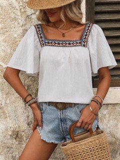 Styled front view of the white embroidered square-neck blouse, showing its silhouette and design details.
