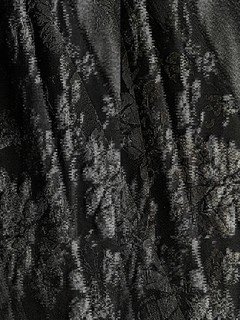 Fabric detail of the black floral-embossed square-neck sleeveless midi dress, showing raised floral texture, square neckline and midi skirt.