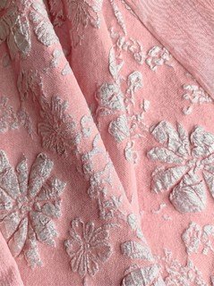 Floral texture detail of the pink floral-embossed square-neck sleeveless midi dress, showing raised floral texture, square neckline and midi skirt.