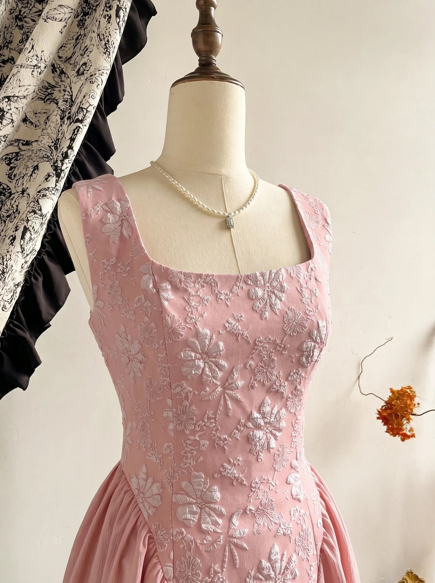 Mannequin bodice view of the pink floral-embossed square-neck sleeveless midi dress, showing the silhouette and fit.