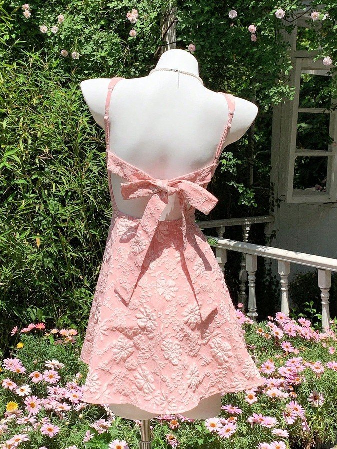 Mannequin back view of the pink floral-jacquard bow-back fit-and-flare mini dress, showing the silhouette and fit.