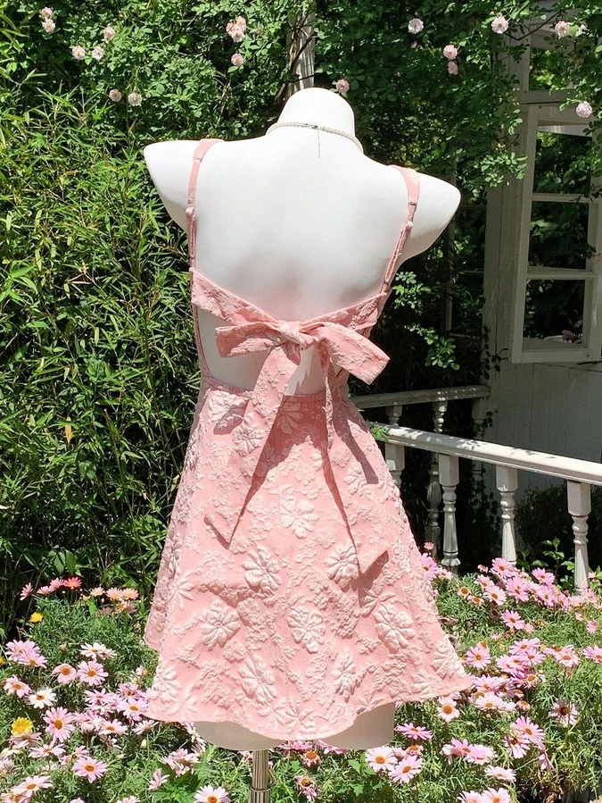 Mannequin back view of the pink floral-jacquard bow-back fit-and-flare mini dress, showing the silhouette and fit.