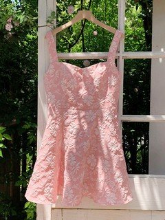 Hanging front view of the pink floral-jacquard bow-back fit-and-flare mini dress, showing the silhouette and fit.