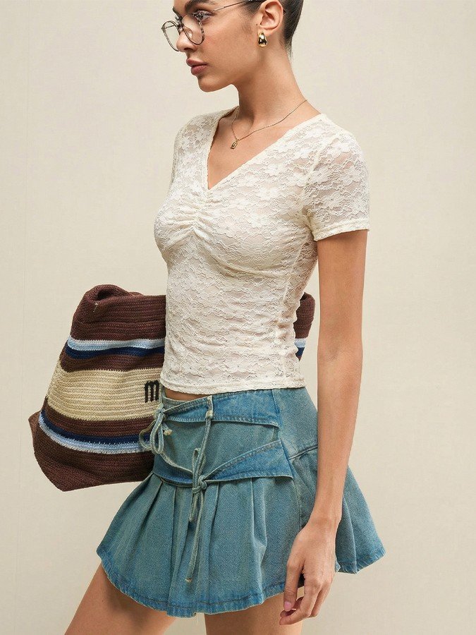 Front view of the cream floral lace ruched v-neck top, showing its silhouette and design details.