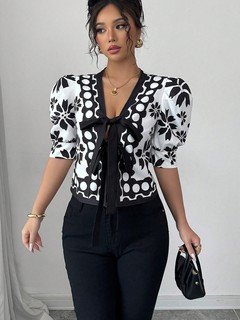 Front view of the black and white floral puff-sleeve tie-front top, showing its silhouette and design details.