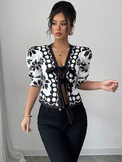 Styled front view of the black and white floral puff-sleeve tie-front top, showing its silhouette and design details.
