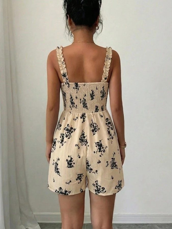 Back view of the cream floral smocked ruffle-strap romper, showing its silhouette and design details.