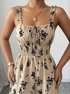 Design close-up of the cream floral smocked ruffle-strap romper, showing its silhouette and design details.