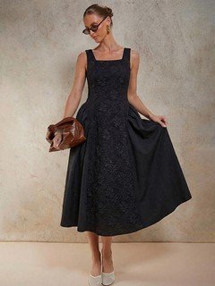 Angled front view of the black floral textured square-neck dress, showing its silhouette and design details.