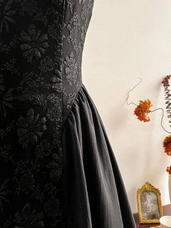 Construction detail of the black floral textured square-neck dress, showing the garment finish.