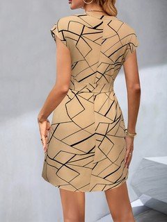 Back view of the tan and black geometric line print tie-waist dress, showing its silhouette and design details.