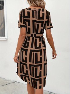 Back view of the black and tan geometric belted shirt dress, showing its silhouette and design details.