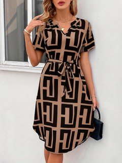 Full-length front view of the black and tan geometric belted shirt dress, showing its silhouette and design details.