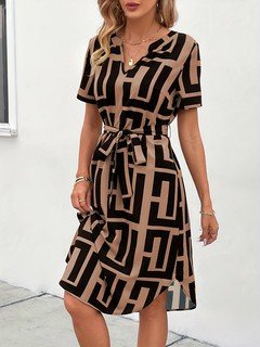 Styled front view of the black and tan geometric belted shirt dress, showing its silhouette and design details.