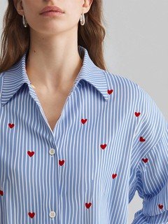 Close-up of the blue heart motif striped shirt, showing its silhouette and design details.