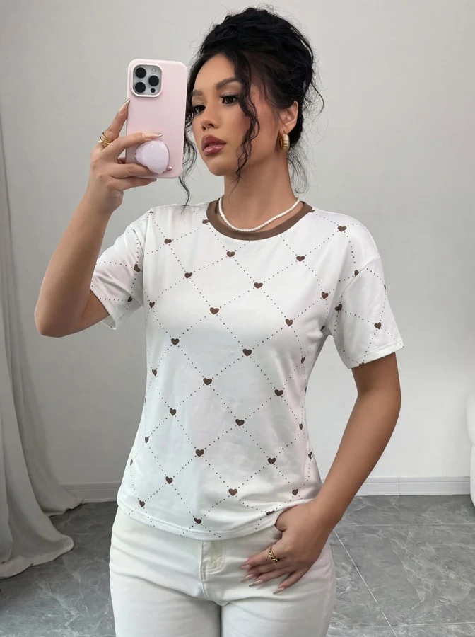 Front view of the white heart-print crew-neck short-sleeve t-shirt, showing the silhouette and fit.