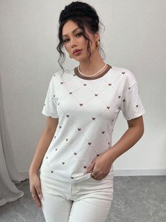 Angled front view of the white heart-print crew-neck short-sleeve t-shirt, showing the silhouette and fit.