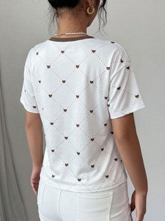 Back view of the white heart-print crew-neck short-sleeve t-shirt, showing the silhouette and fit.