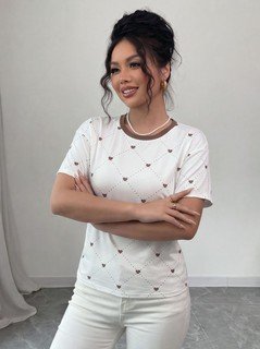 Front close up of the white heart-print crew-neck short-sleeve t-shirt, showing small heart print, crew neckline and relaxed fit.