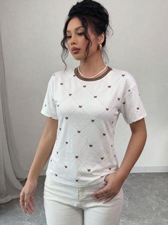 Styled front view of the white heart-print crew-neck short-sleeve t-shirt, showing the silhouette and fit.