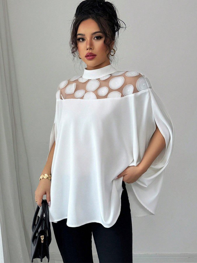 Angled front view of the white circle lace yoke cape blouse, showing its silhouette and design details.