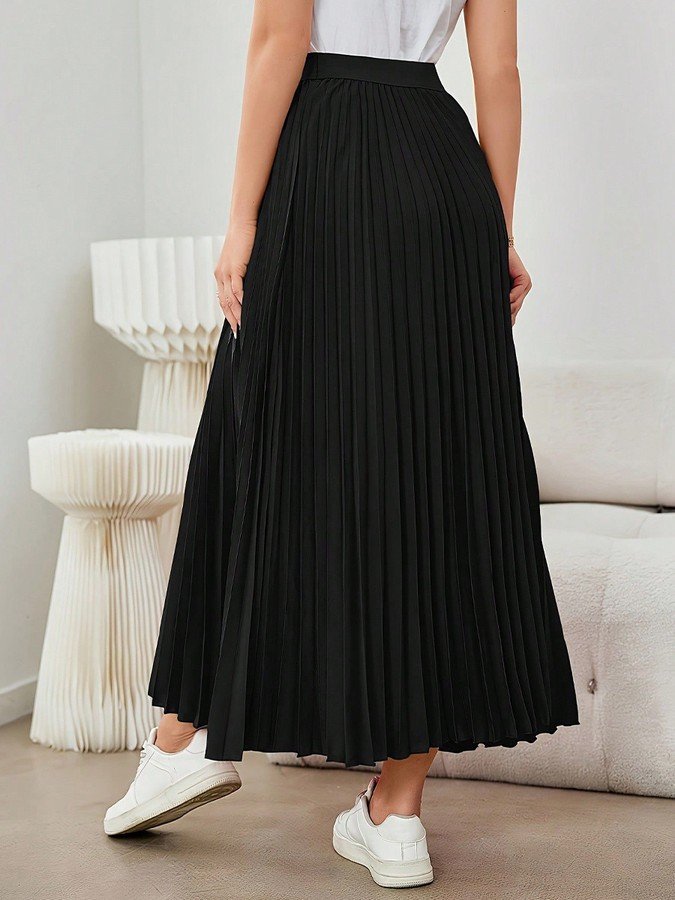 Back view of the black accordion-pleated maxi skirt, showing its silhouette and design details.
