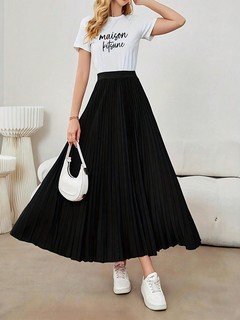 Styled front view of the black accordion-pleated maxi skirt, showing its silhouette and design details.