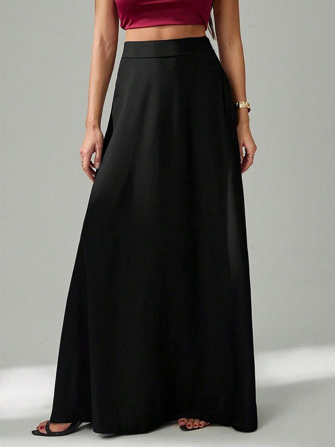 Angled front view of the black pleated a-line maxi skirt, showing its silhouette and design details.