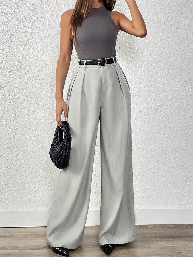 Angled front view of the light gray pleated wide-leg tailored pants, showing its silhouette and design details.