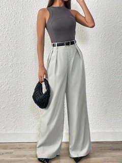 Lifestyle front view of the light gray pleated wide-leg tailored pants, showing its silhouette and design details.