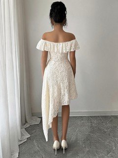 Back view of the white lace off-shoulder asymmetric midi dress, showing the silhouette and fit.