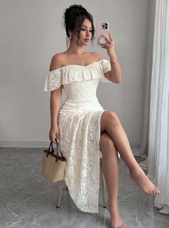 Seated front view of the white lace off-shoulder asymmetric midi dress, showing the silhouette and fit.