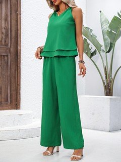 Angled front view of the green layered sleeveless top and wide-leg pants set, showing the silhouette and fit.
