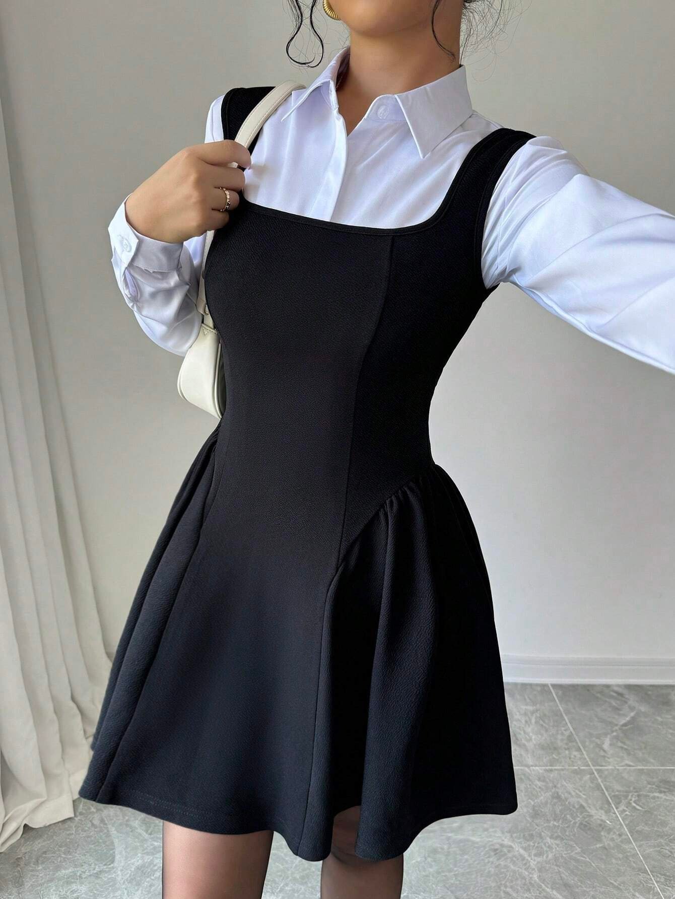 Layered front view of the black layering square-neck sleeveless skater mini dress, showing the silhouette and fit.