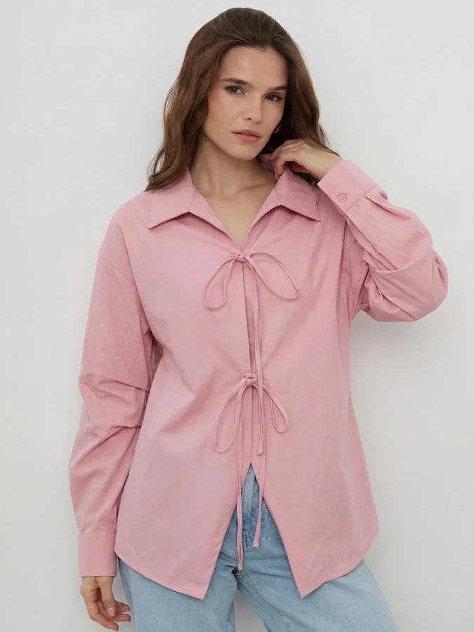 Front view of the pink bow-tie front collared shirt, showing its silhouette and design details.
