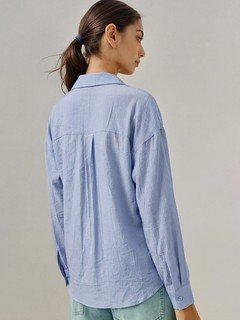 Back view of the blue collared side-tie wrap shirt, showing its silhouette and design details.