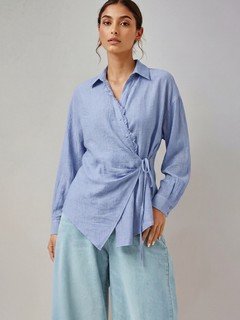Front view of the blue collared side-tie wrap shirt, showing its silhouette and design details.