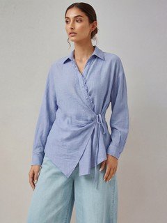 Full-length front view of the blue collared side-tie wrap shirt, showing its silhouette and design details.