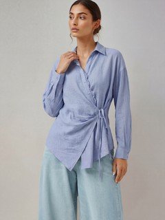 Lifestyle front view of the blue collared side-tie wrap shirt, showing its silhouette and design details.
