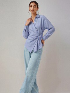 Styled front view of the blue collared side-tie wrap shirt, showing its silhouette and design details.