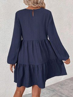 Back view of the navy long-sleeve tiered smock dress, showing its silhouette and design details.