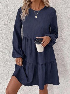 Full-length front view of the navy long-sleeve tiered smock dress, showing its silhouette and design details.