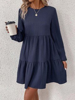 Lifestyle front view of the navy long-sleeve tiered smock dress, showing its silhouette and design details.
