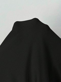 Fabric detail of the black long-sleeve bubble hem dress, showing the surface texture and finish.