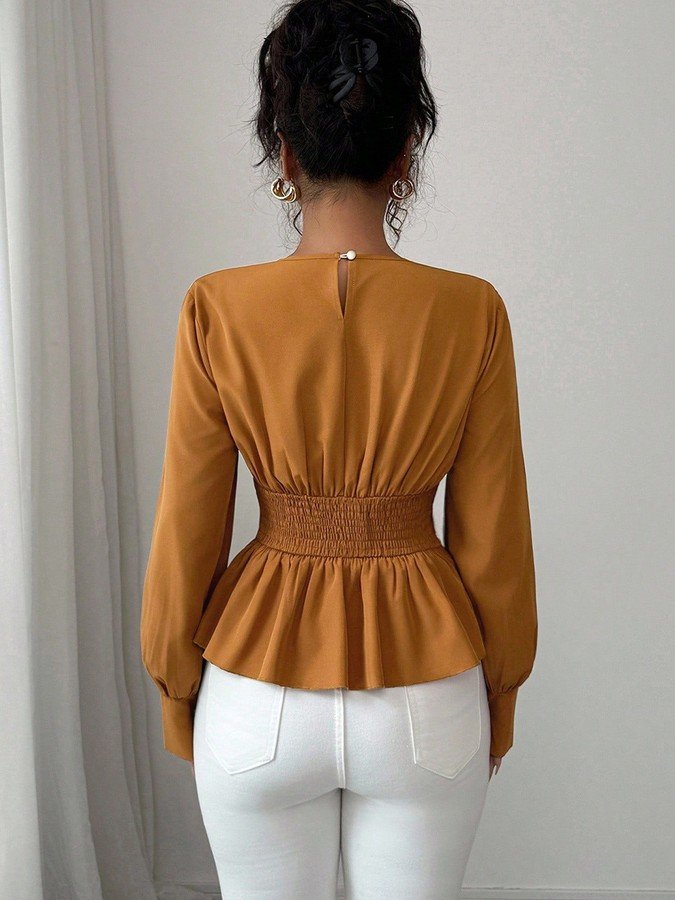 Back view of the ochre tailored long-sleeve peplum blouse, showing its silhouette and design details.