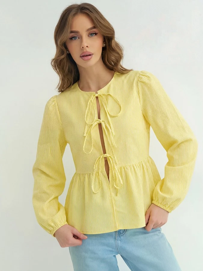 Front view of the yellow tie-front long-sleeve blouse, showing its silhouette and design details.