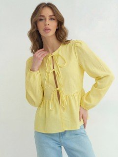 Lifestyle front view of the yellow tie-front long-sleeve blouse, showing its silhouette and design details.