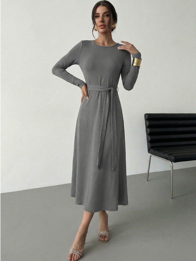 Angled front view of the gray tie-waist long-sleeve midi dress, showing its silhouette and design details.