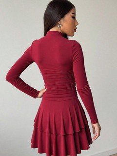 Back view of the red long-sleeve tiered ruffle dress, showing its silhouette and design details.